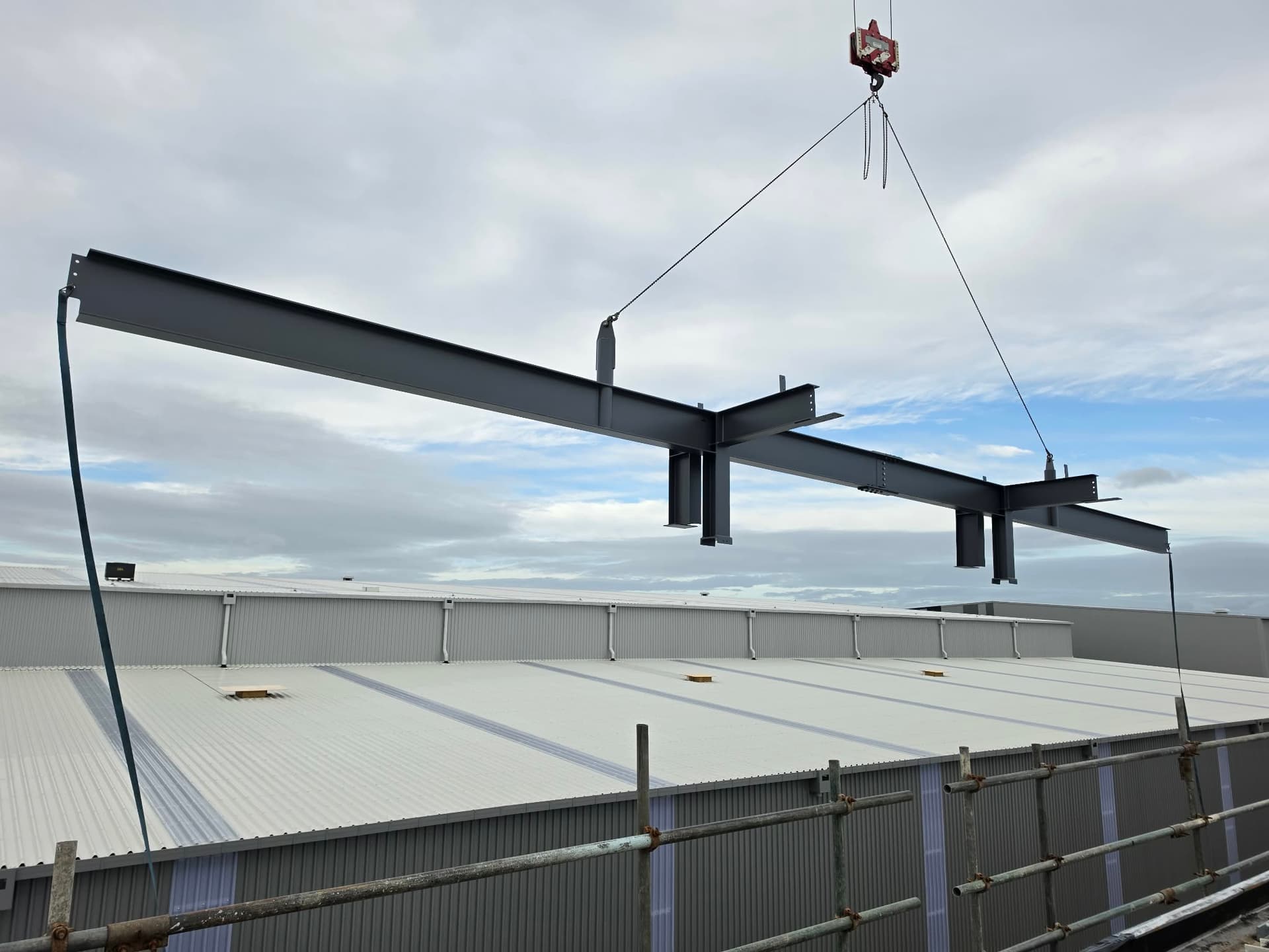 Steel rigging crew positioning structural beam on site in New Zealand